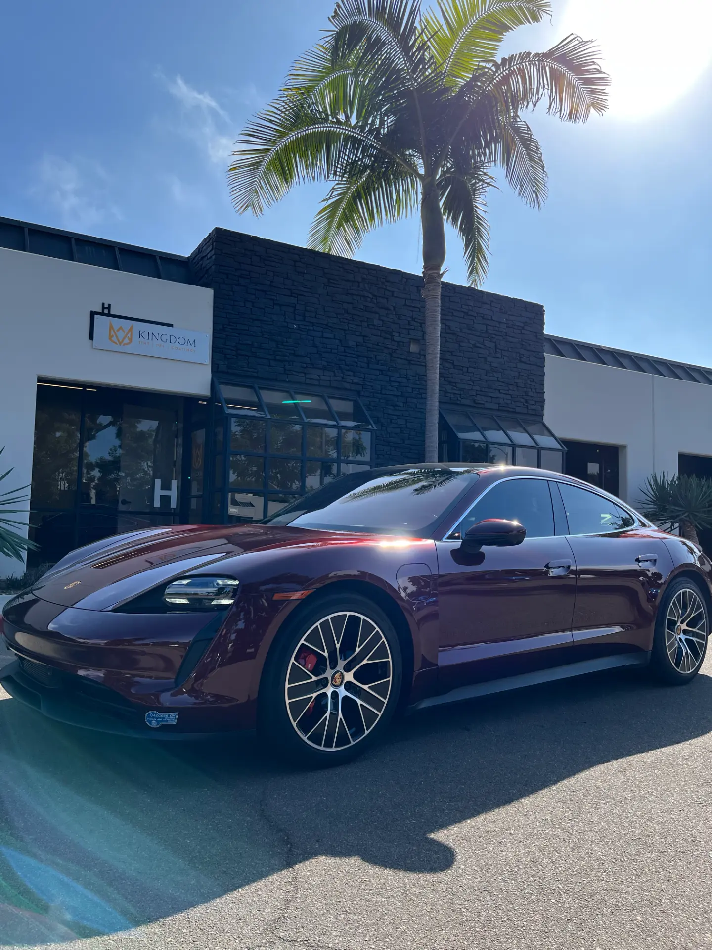 Burgundy Porsche Taycan with a glossy finish in the sun