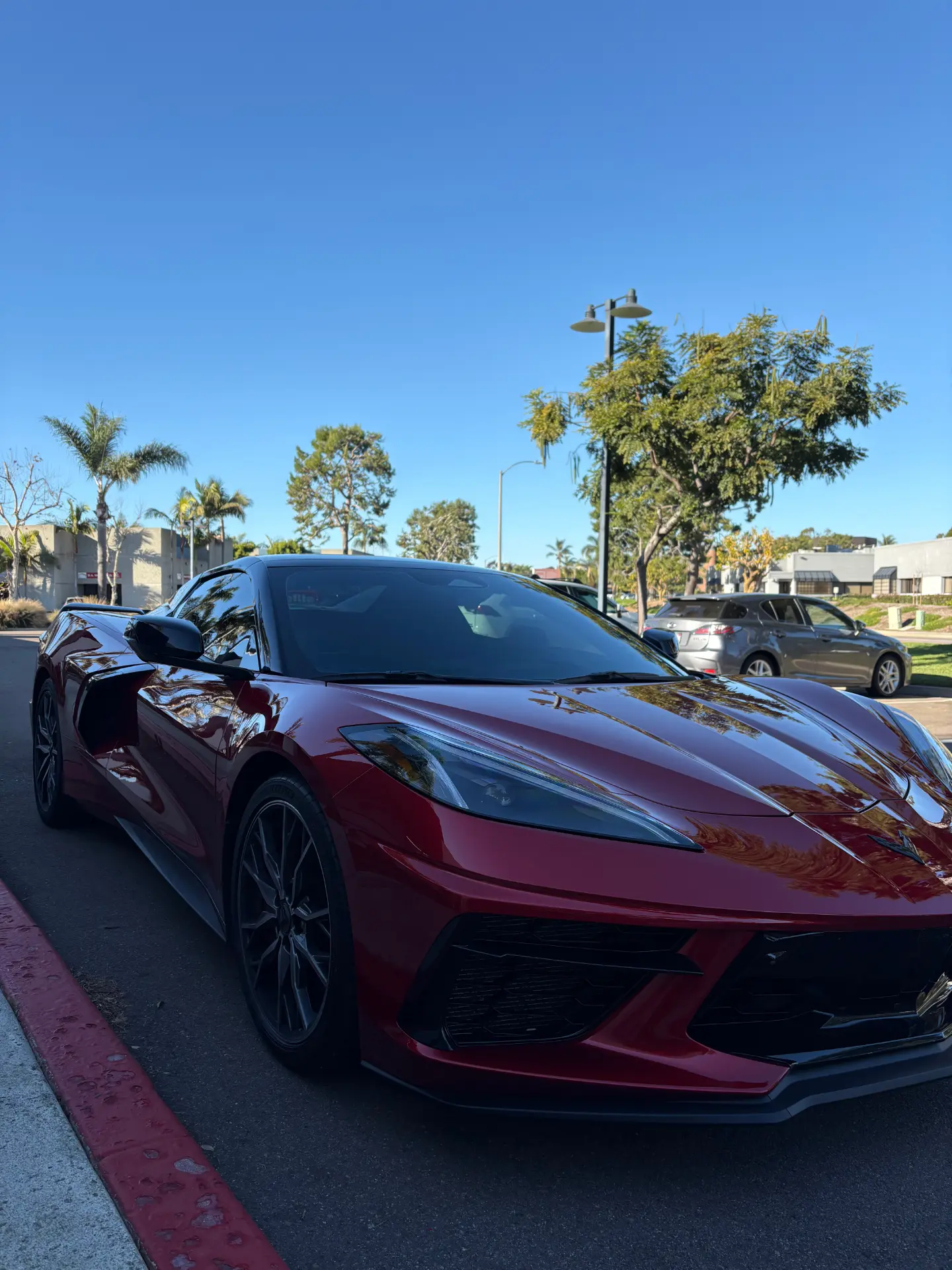 Glossy red Corvette C8 parked curbside