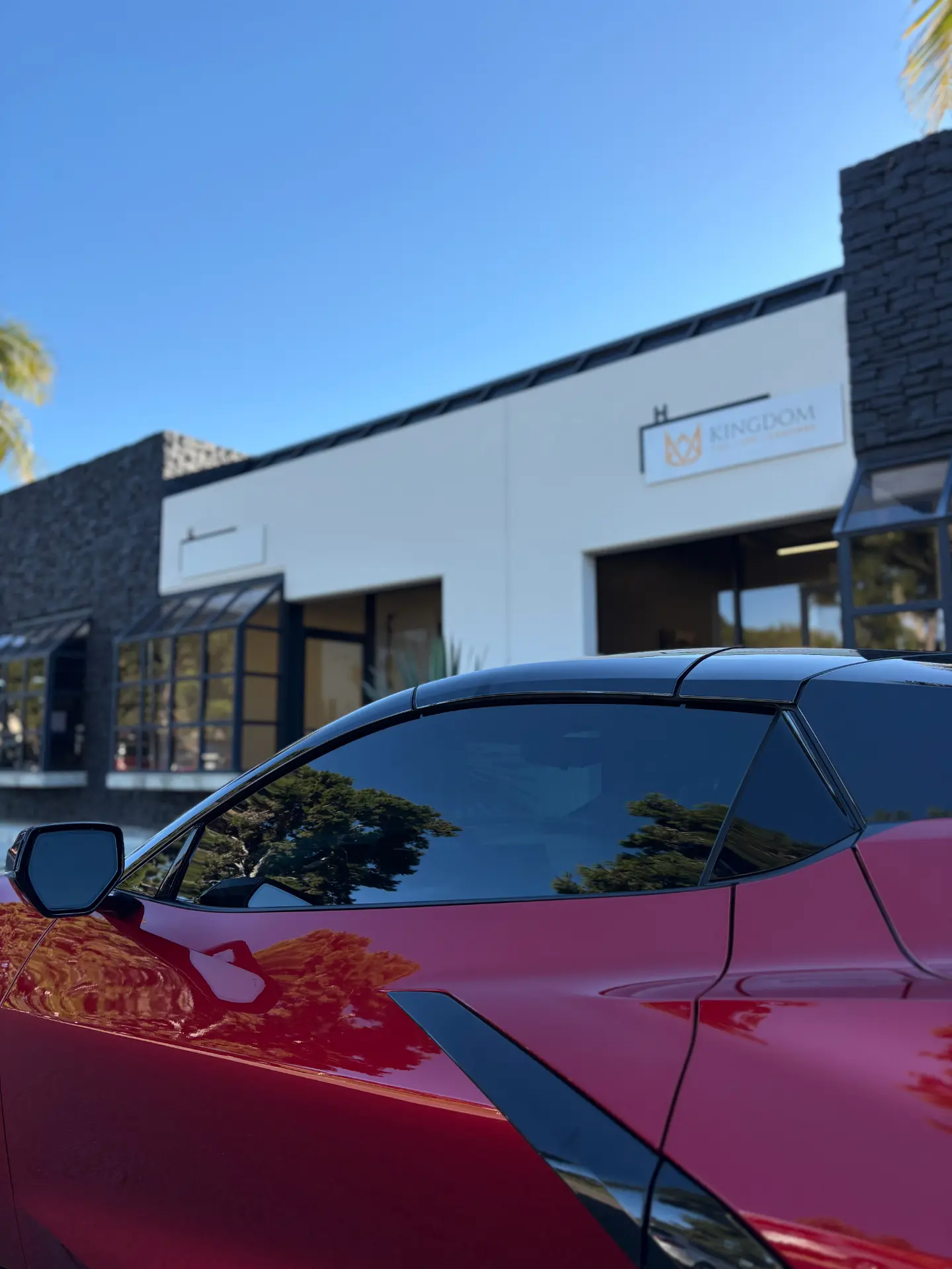 Red Chevrolet Corvette with dark ceramic window tint outside the Kingdom Tint shop