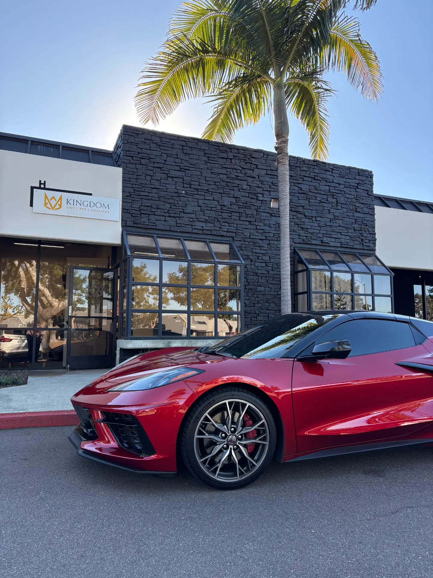 Red Corvette C8 parked outside the Kingdom Tint shop