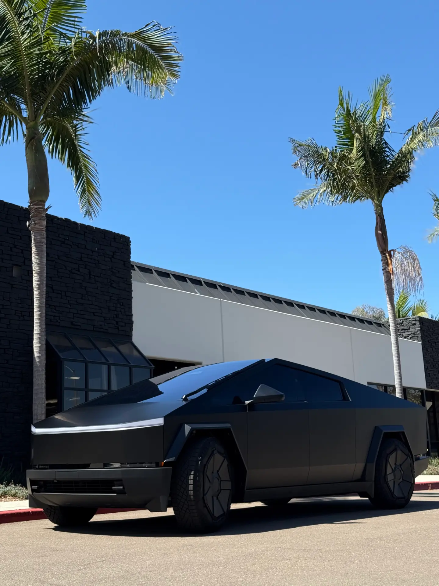 Satin black Tesla Cybertruck with paint protection film outside the Kingdom Tint shop
