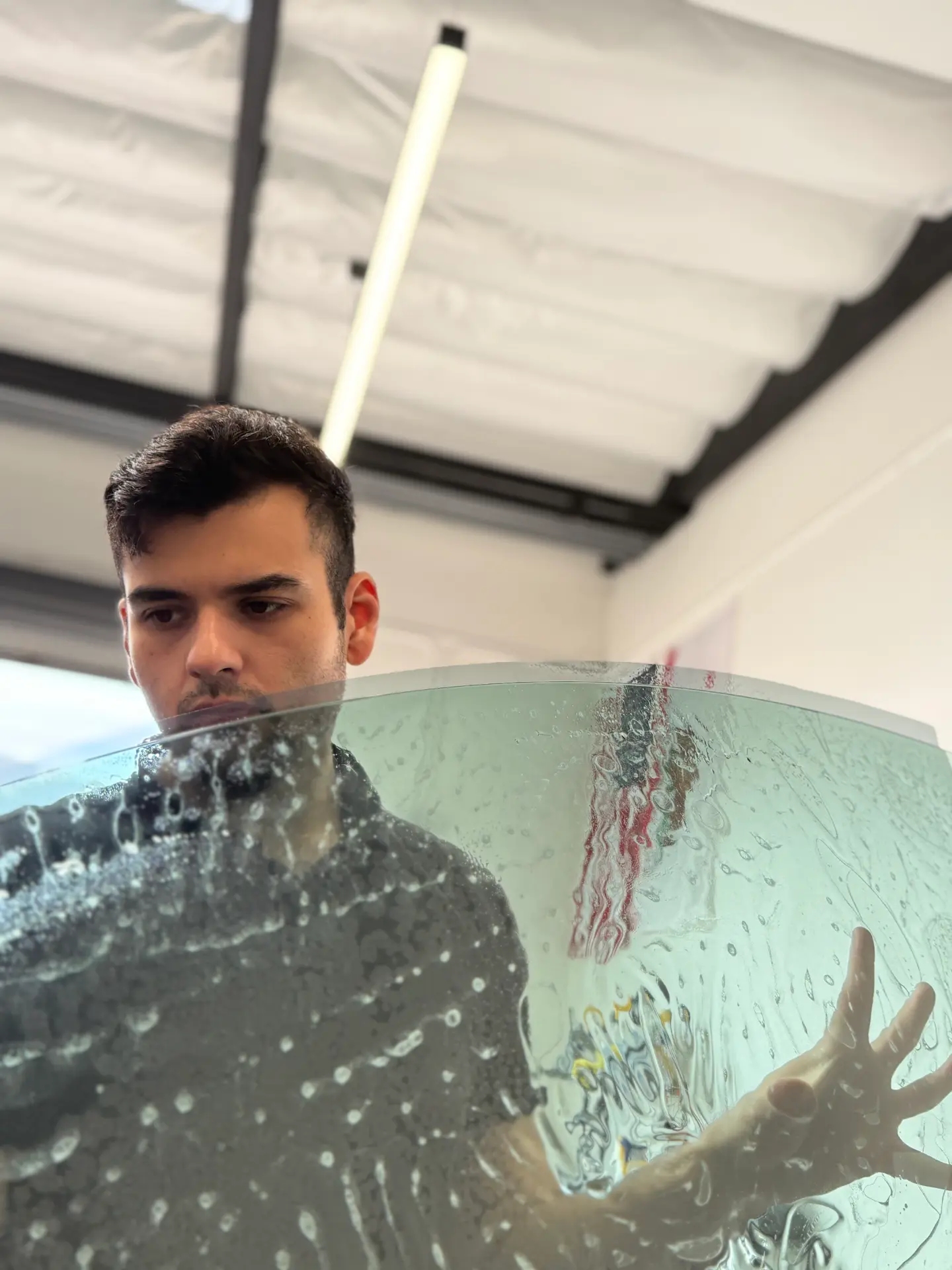 Kingdom Tint installer squeegeeing window film on curved glass