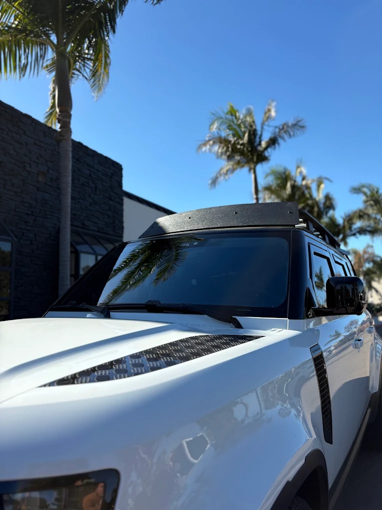 White Land Rover Defender with tinted windshield and windows