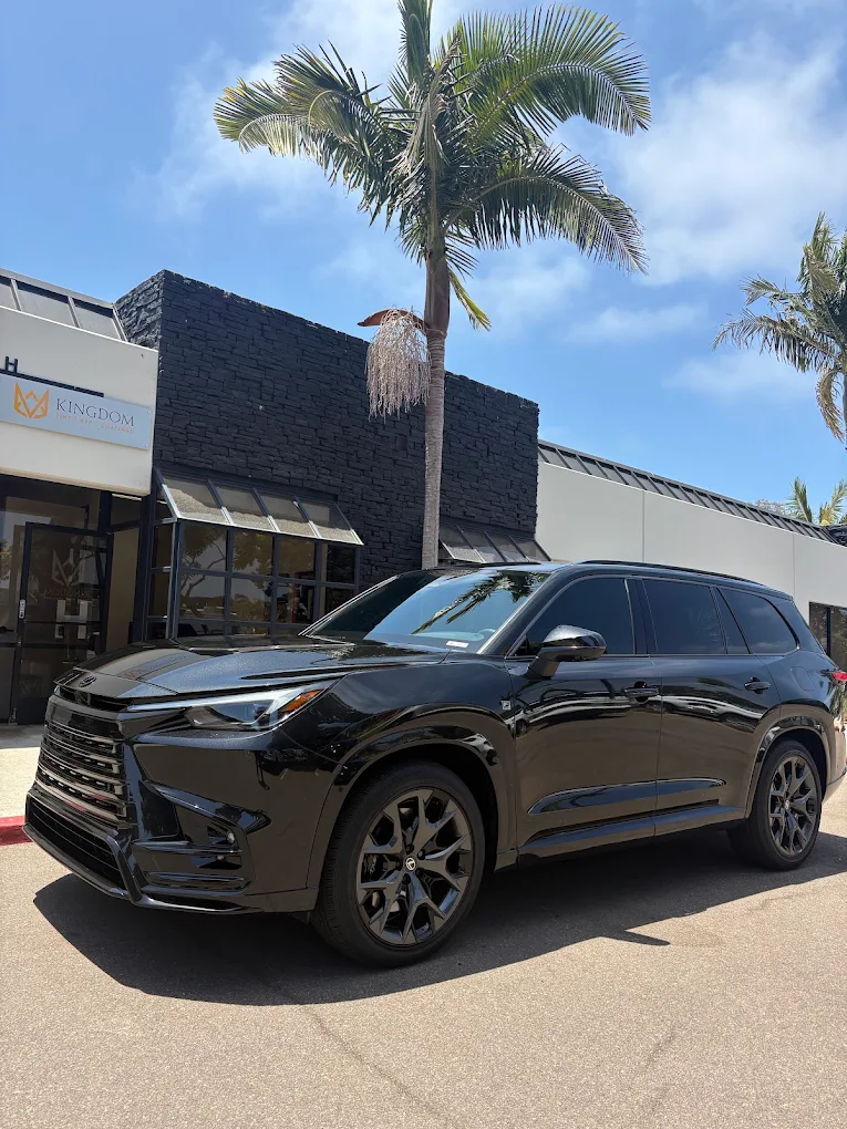 Black SUV with fresh tint parked outside the Kingdom Tint shop